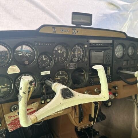 The instrument panel of a Cessna 150 aircraft with various gauges and controls.