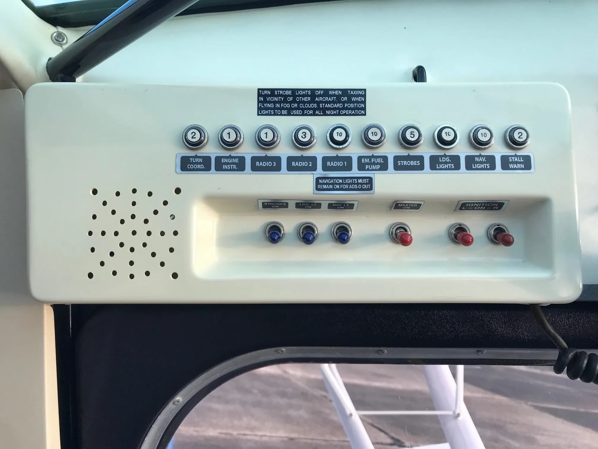 A close-up of the overhead switch panel in the Super Decathlon cockpit, showing various controls and labels.