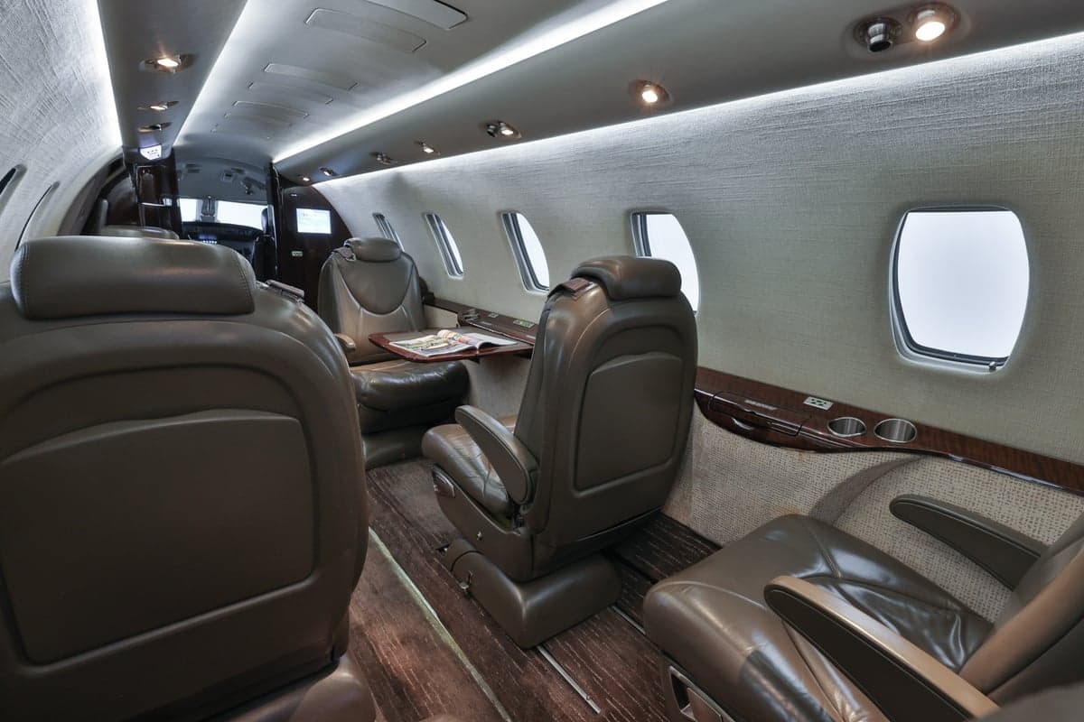 The Citation CJ3 cabin features leather seats and wood-grain accents.