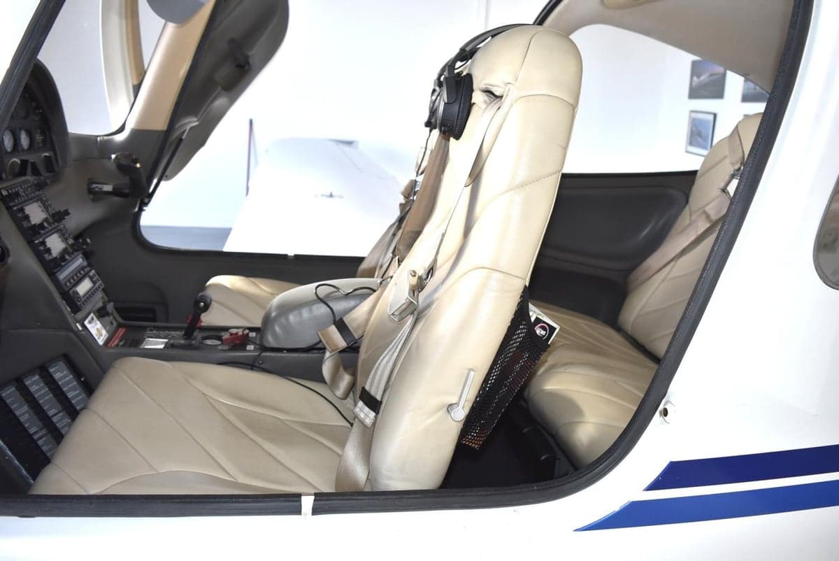 A side view of the beige leather front seats and part of the cockpit in a Cirrus SR20.