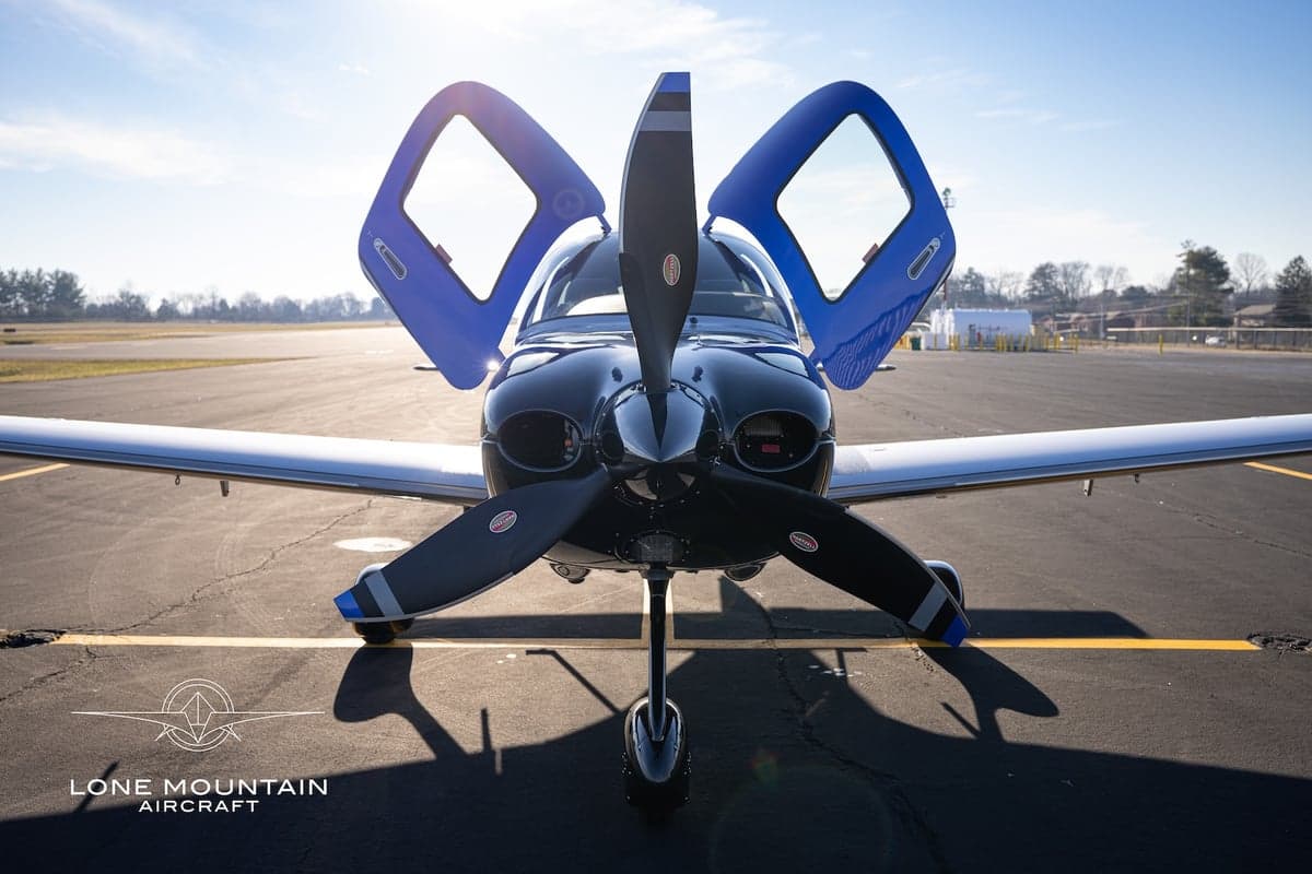 Front view of the Cirrus SR22T aircraft with registration N264KH, showing the open doors and propeller.