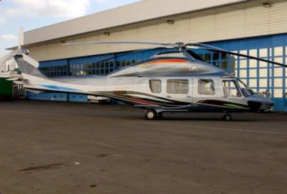 AgustaWestland AW139 helicopter parked in front of a hangar.
