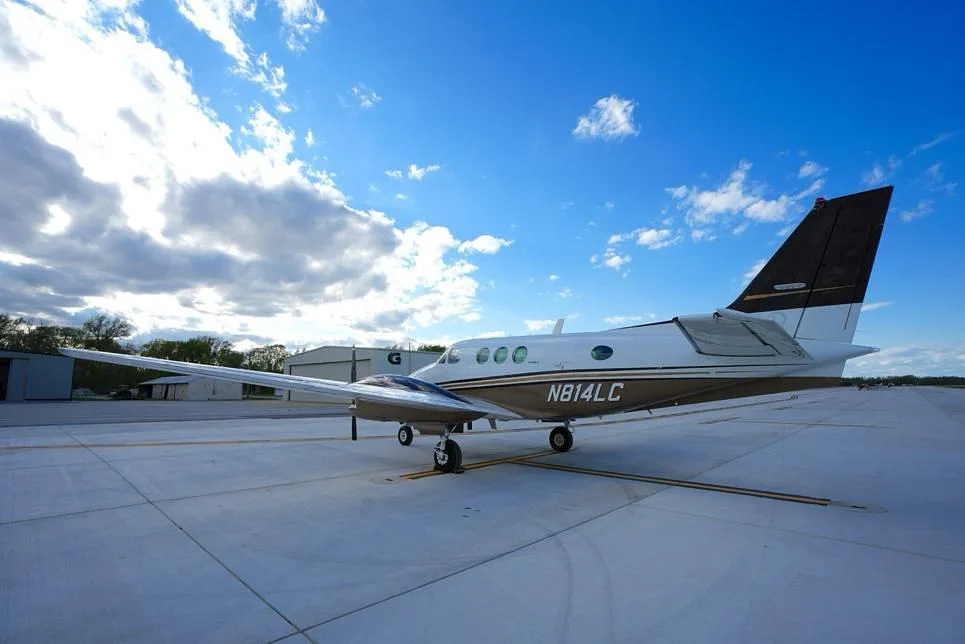 A low-angle side view of the Beechcraft King Air 200, registration N814LC, on an airfield.