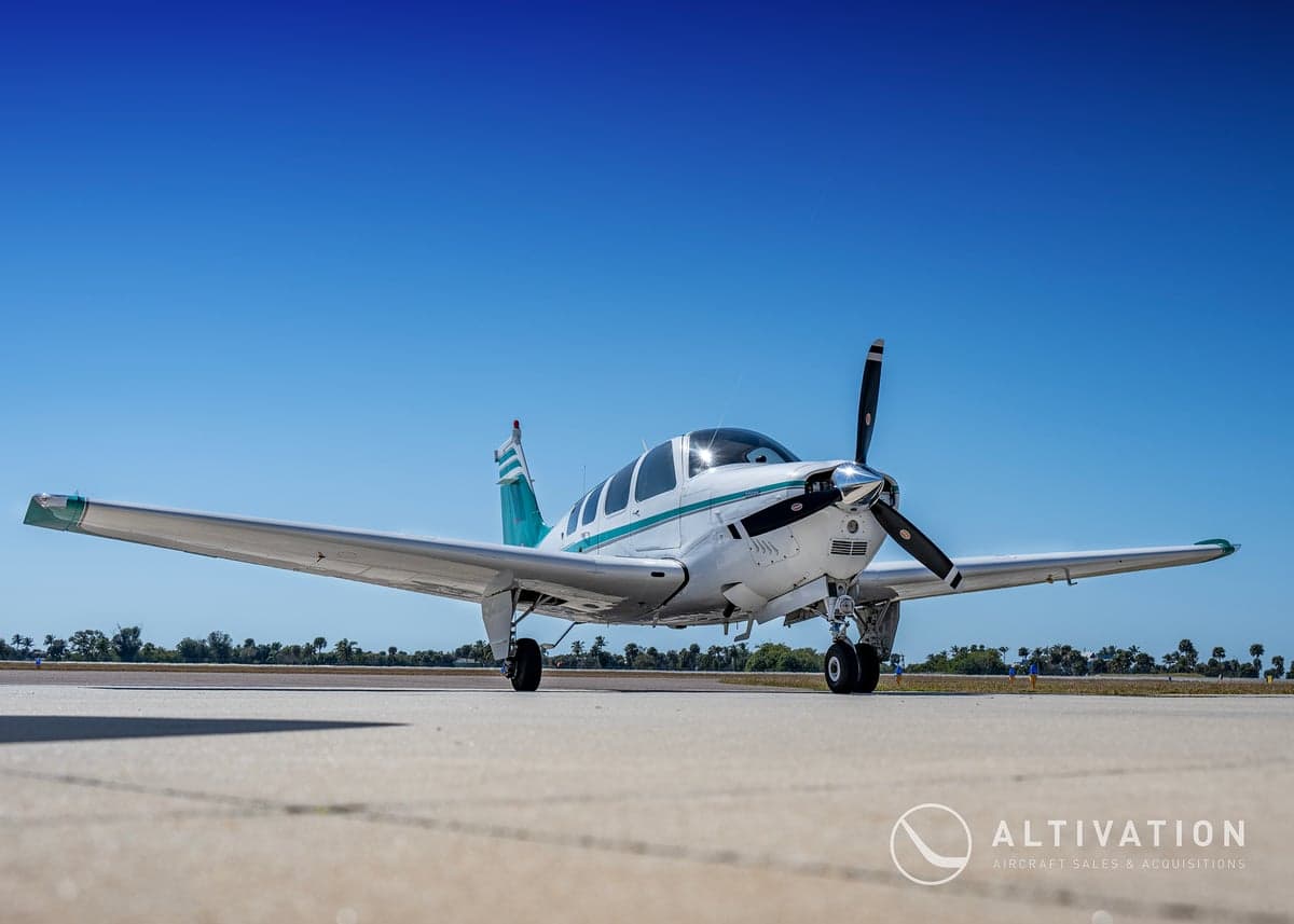 Front view of a Beechcraft Bonanza with a white and green paint scheme.