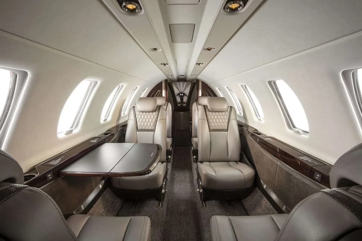 A view of the aircraft's interior cabin with leather seats and a table.