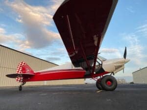 A low angle view of a red and white Cubcrafters FX-3 aircraft.