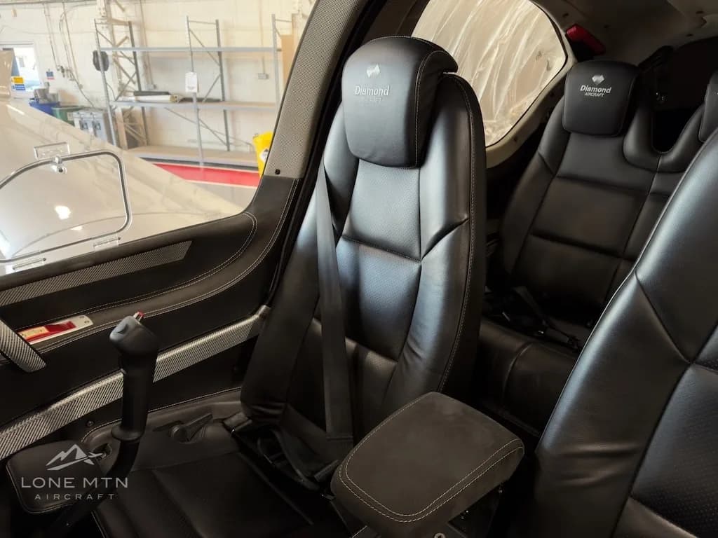 The black leather pilot and co-pilot seats of a Diamond DA50 aircraft, showing the joystick control.