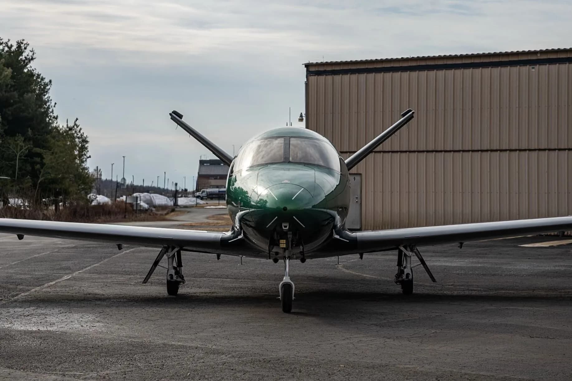A head-on view of the Cirrus Vision Jet N520TD in green and black paint scheme on an airfield.