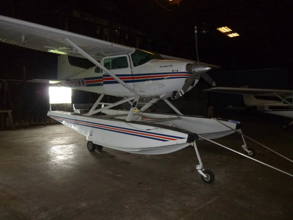 Cessna Skywagon 185 floatplane with registration N91MW in a hangar.