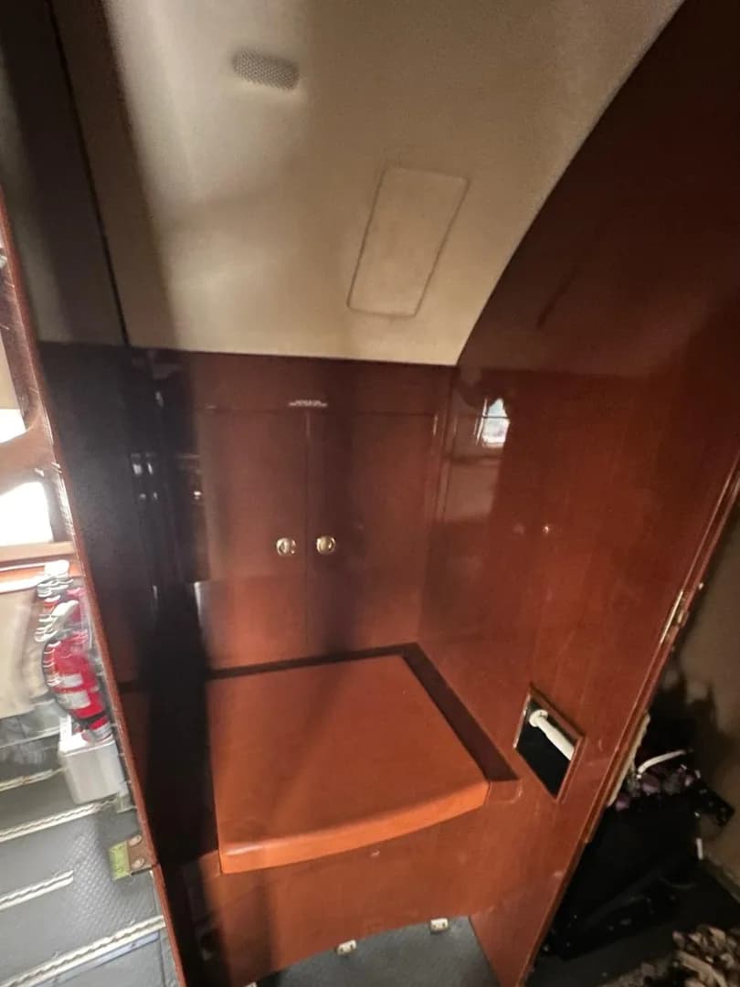 A small compartment in the aircraft's interior, featuring wooden paneling and a toilet seat.