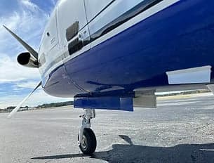 Close-up of the landing gear and underside of a TBM 900 aircraft.