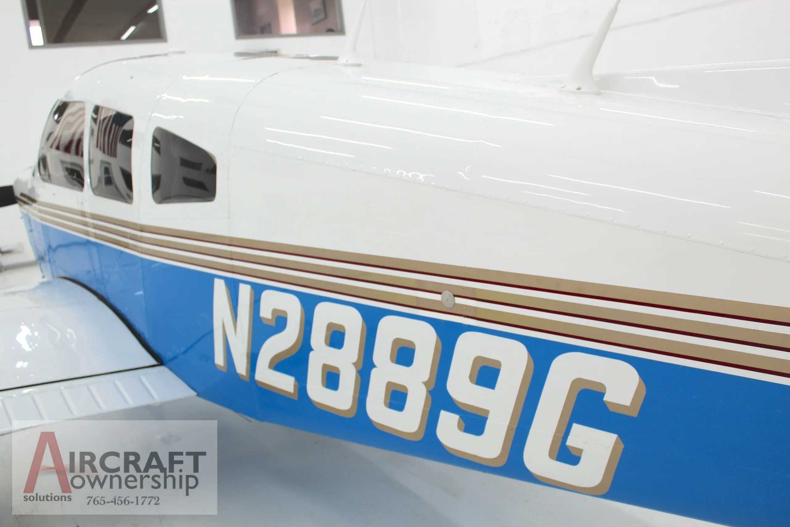 A close-up view of the N2889G registration number on the blue and white fuselage of the Piper Dakota.