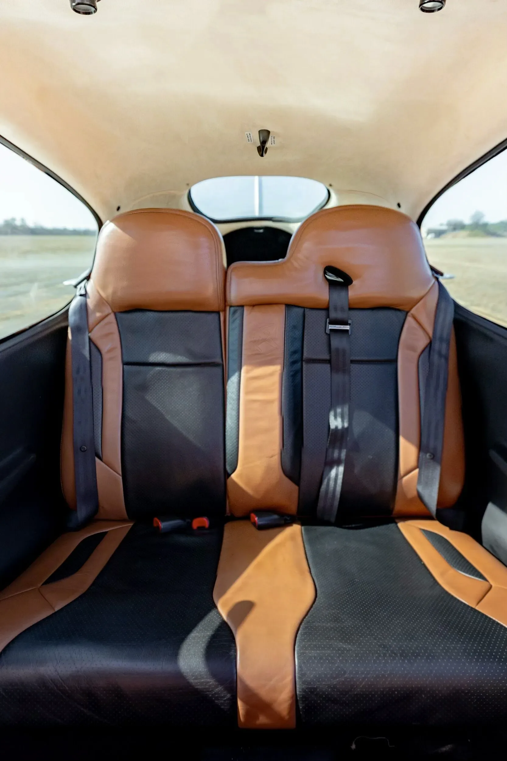 The rear cabin seats of the Cirrus SR20 GTS aircraft, upholstered in two-tone brown and black leather.