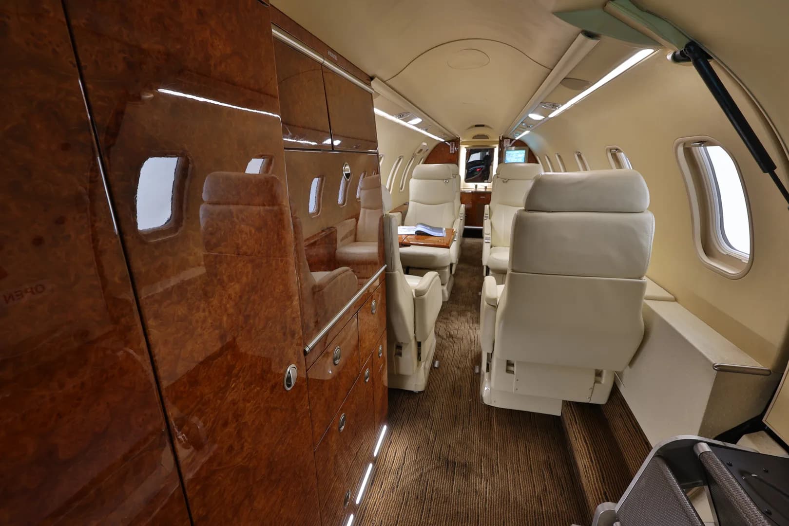View of the cabin interior with cream-colored seats and wood paneling.