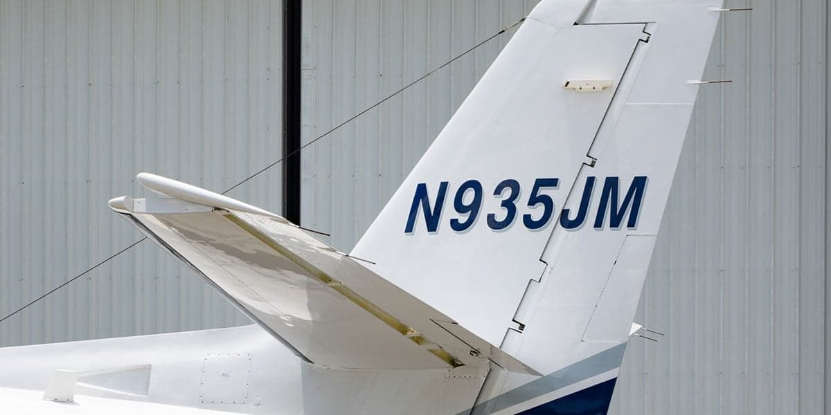 Close-up of the tail section of a Cessna Citation CJ3 aircraft, showing the registration number N935JM.