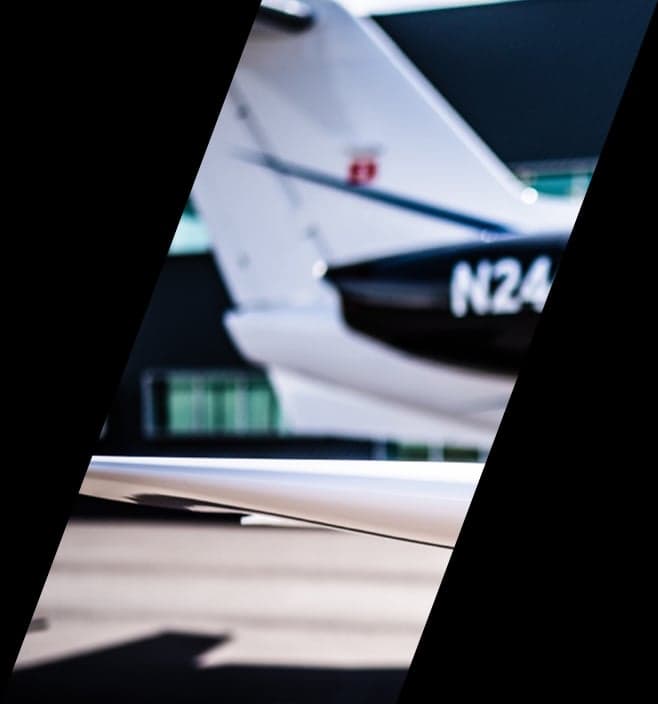 Close-up of the tail section of a white and black jet with registration N24.