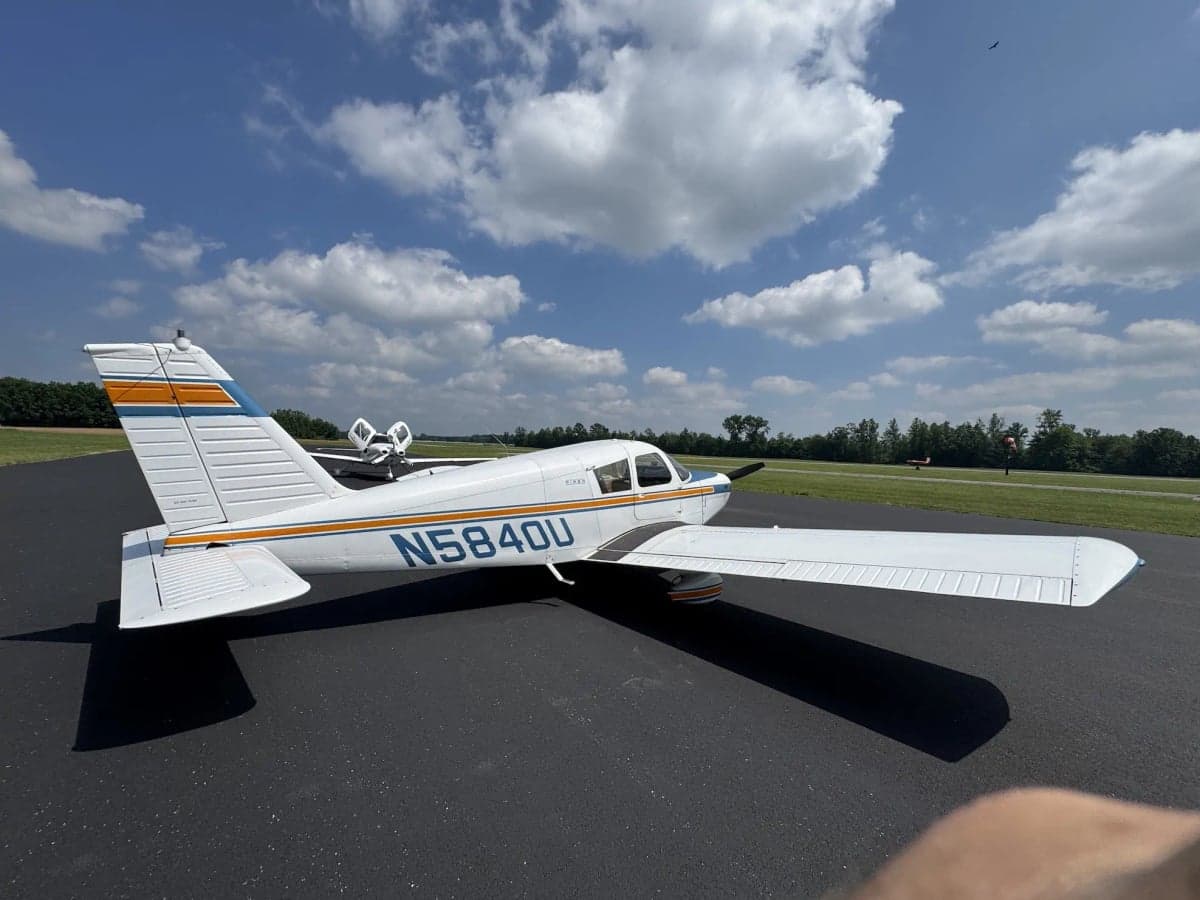 A Piper aircraft with tail number N5840U parked on the tarmac under a cloudy sky.
