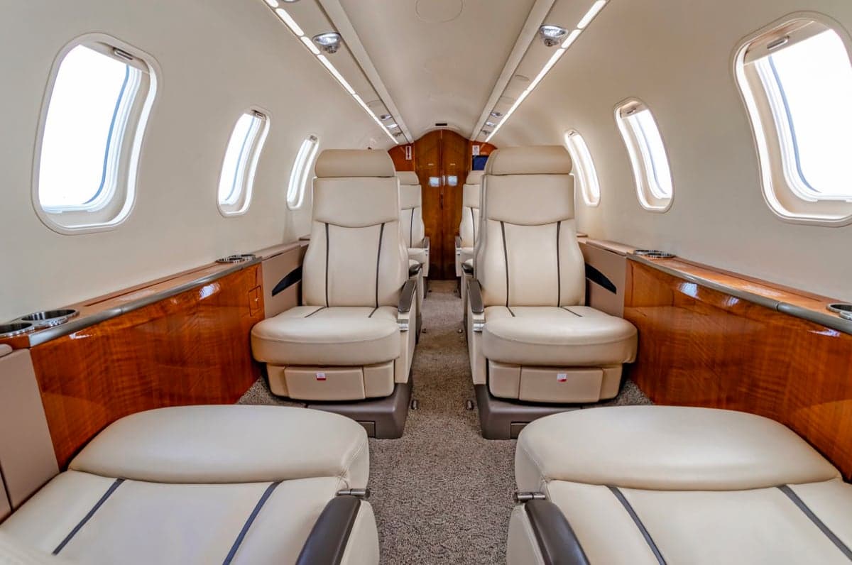View down the aisle of the aircraft cabin with leather seats.