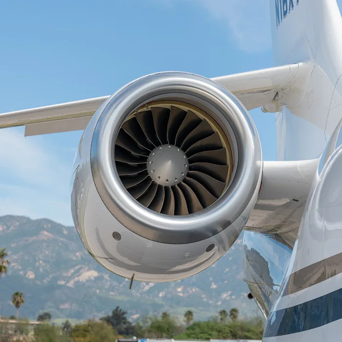 A close-up of the aircraft engine shows the turbine blades.