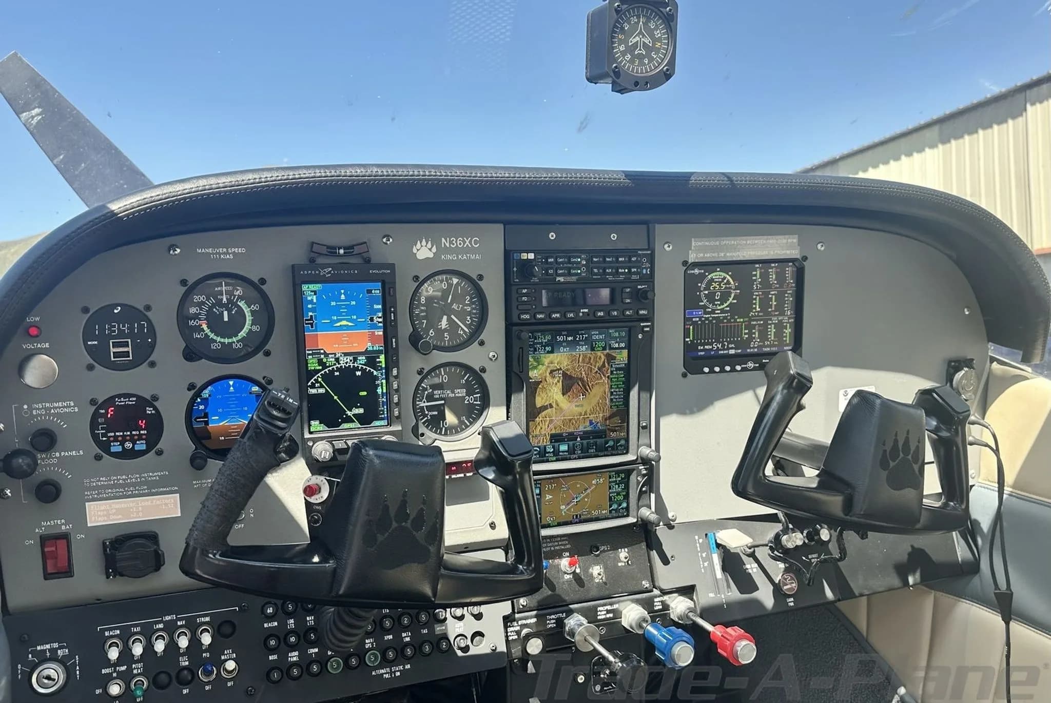 The cockpit of a Cessna 182 aircraft, showing the instrument panel with multiple screens, gauges, and controls.