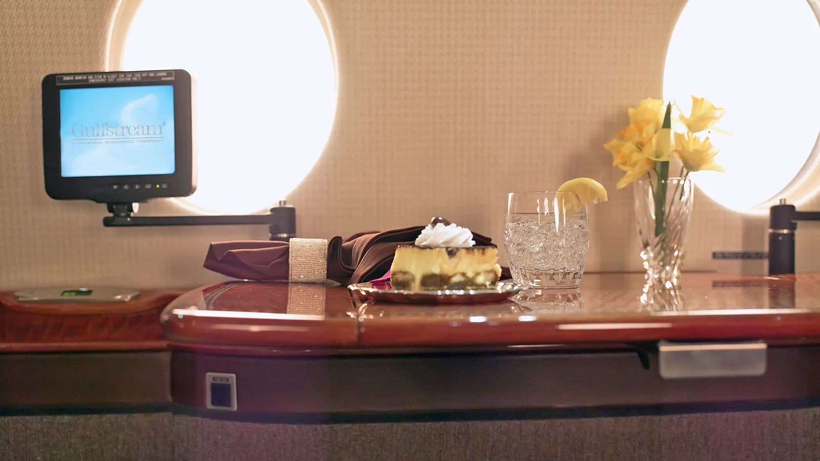 Close up of a table in the aircraft cabin with a drink and dessert.