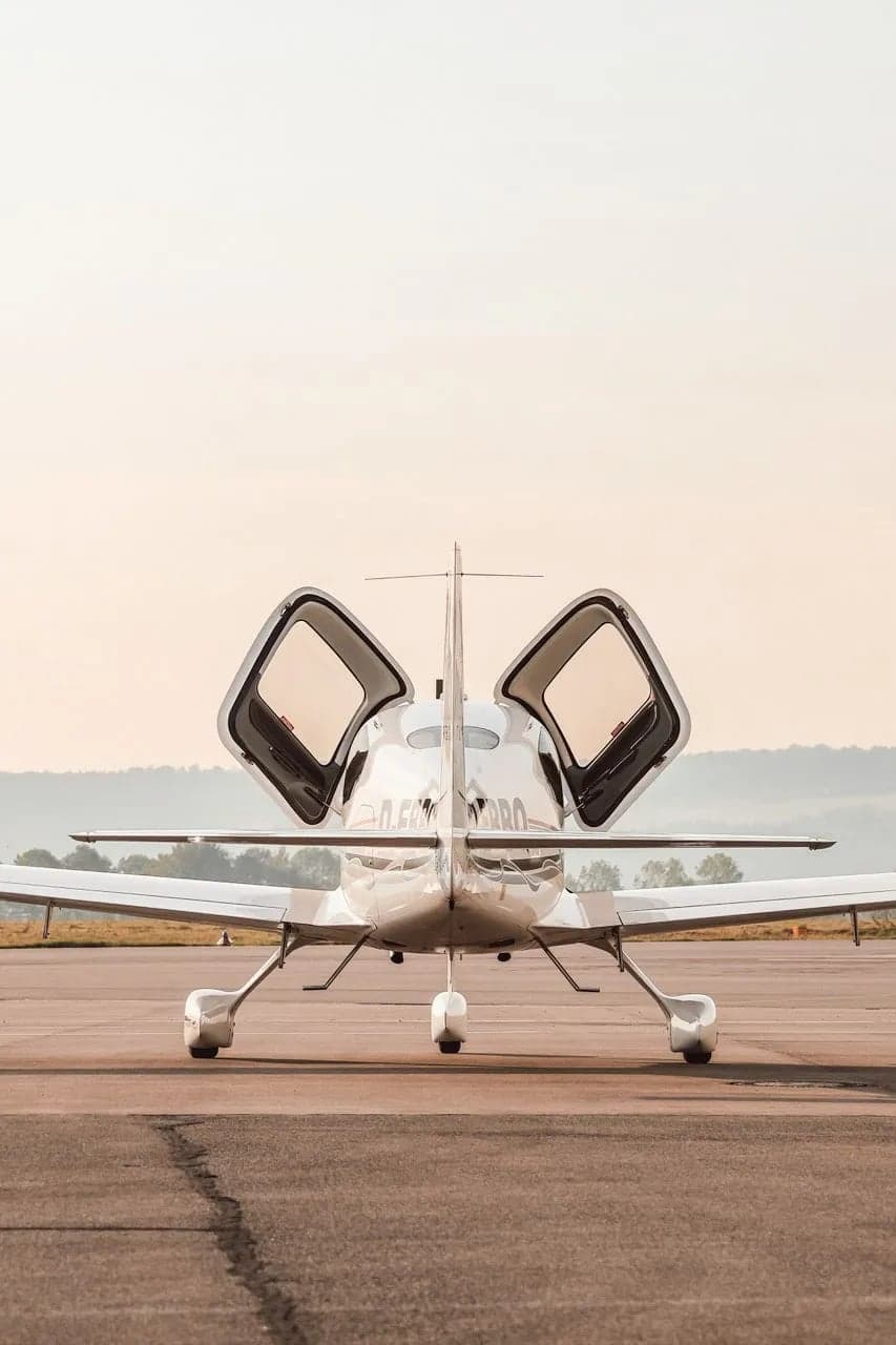 Rear view of a Cirrus aircraft with registration D-EBBQ with its doors open.