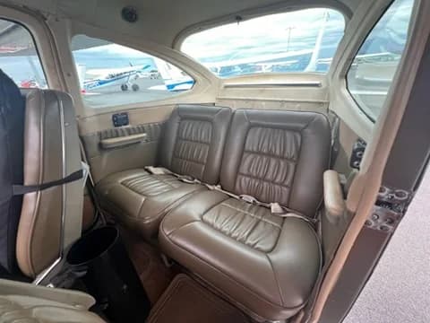 The tan leather rear seats of a Cessna 182 aircraft cabin.