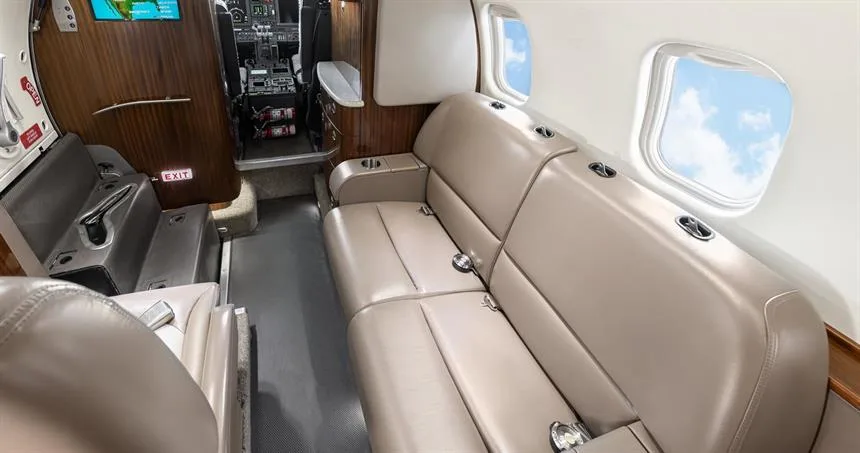 Aircraft cabin with divan and cockpit view.