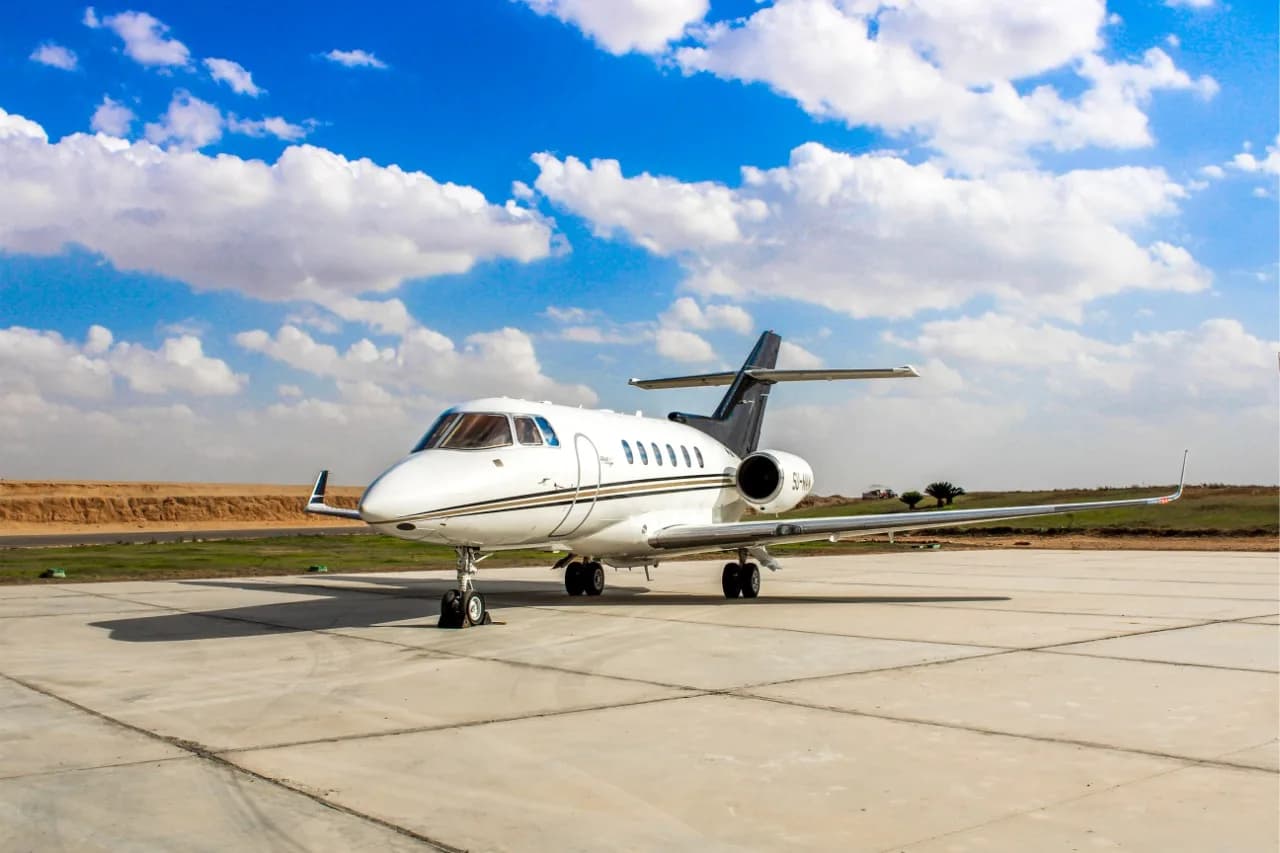SU-MAN aircraft parked on the tarmac with a white and black paint scheme.