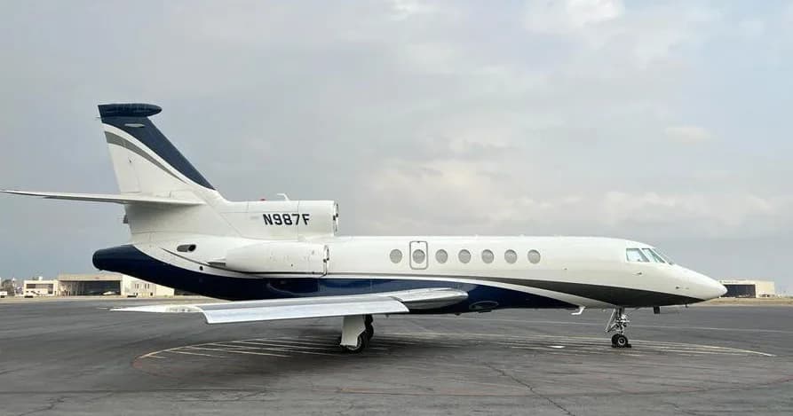Side view of the N987F aircraft on the tarmac.