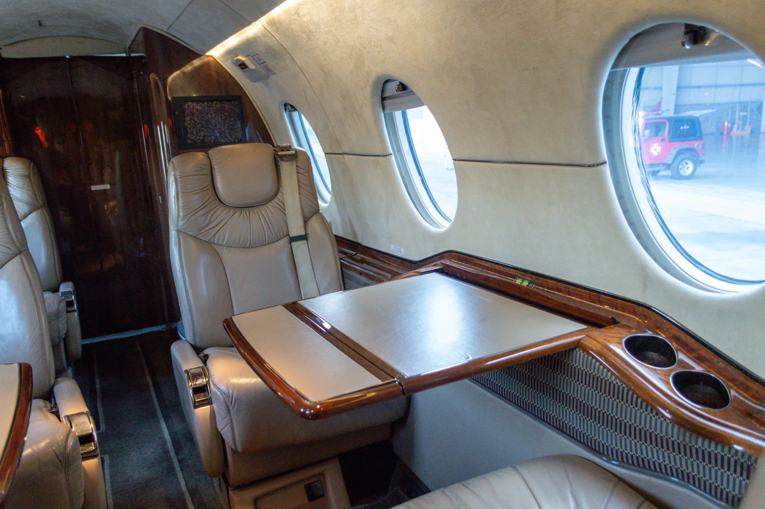 Interior view of the Learjet cabin with leather seats and a table.