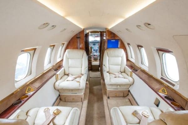 The interior of the aircraft features cream-colored leather seats.