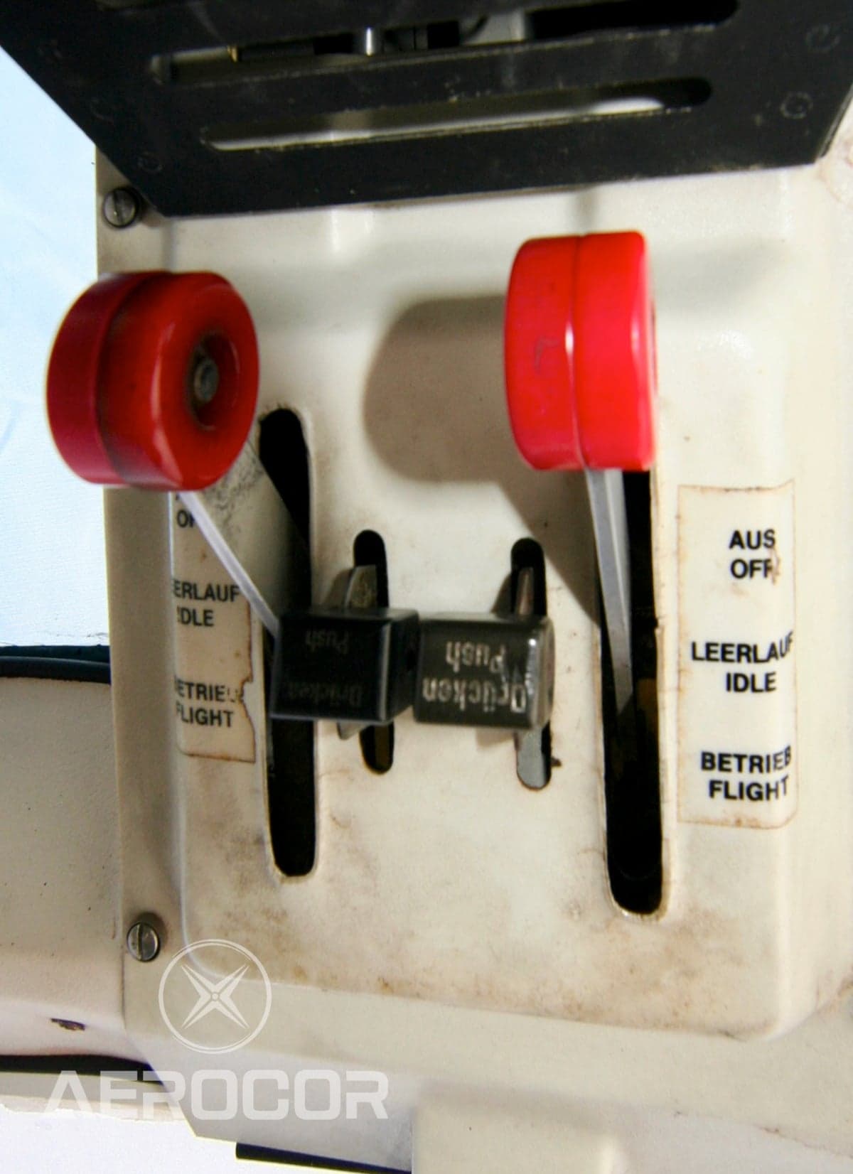 Close-up of the collective pitch and throttle levers in a helicopter cockpit.