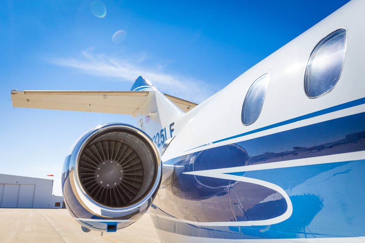 Close up of the engine of a white and blue jet with the registration number N325LF.