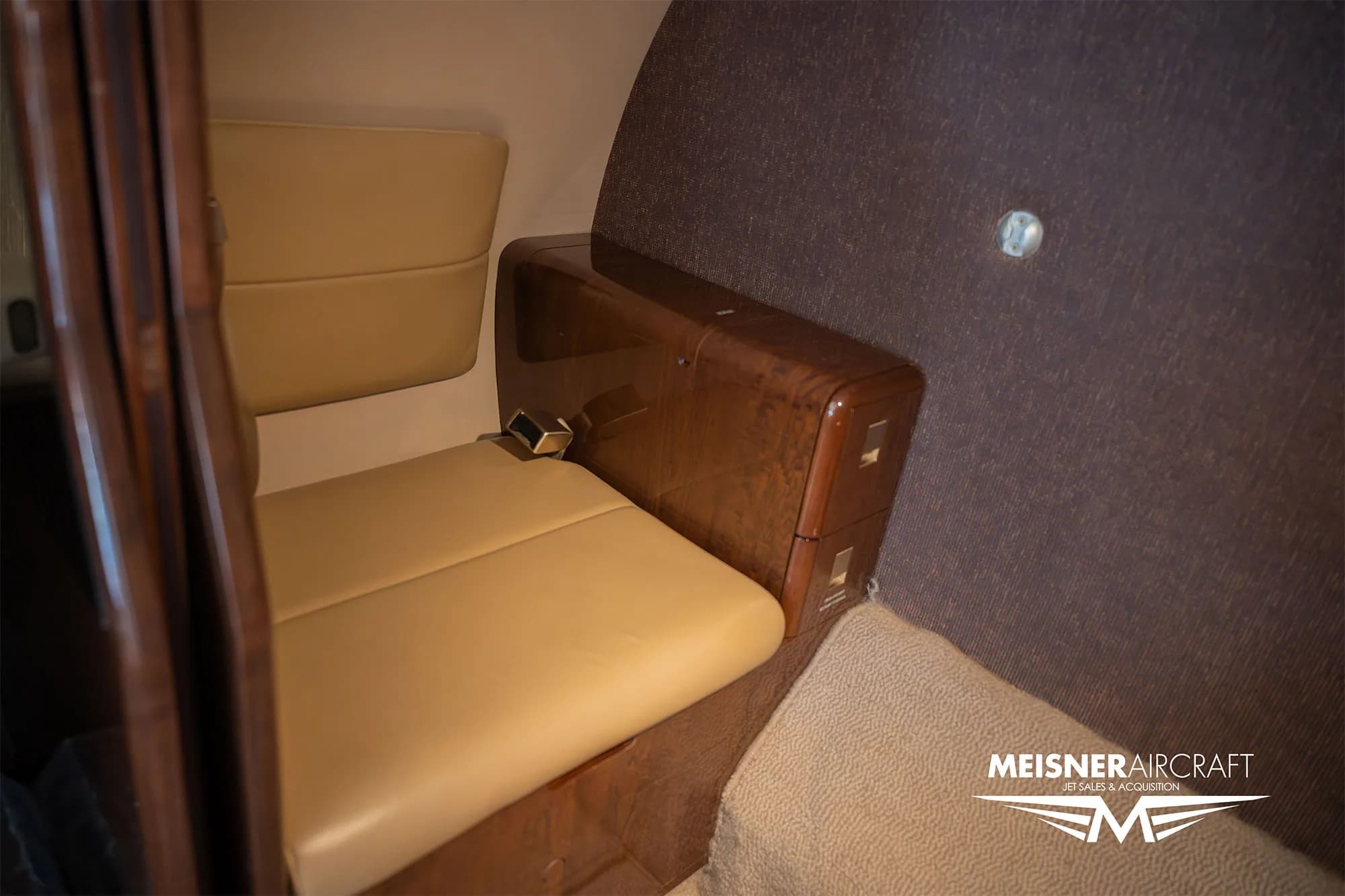 Interior view of a Cessna Citation Encore with tan leather seats and wood trim.