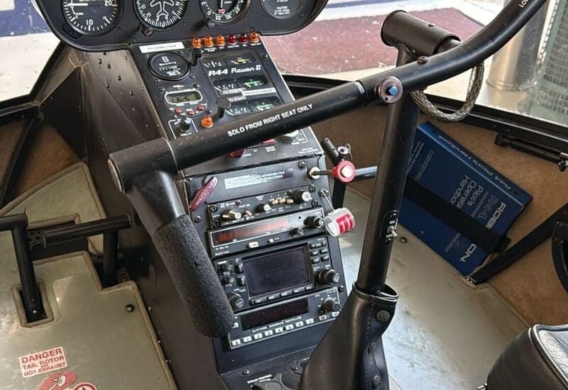 Close-up of the instrument panel and controls in the cockpit of a Robinson R44 helicopter.