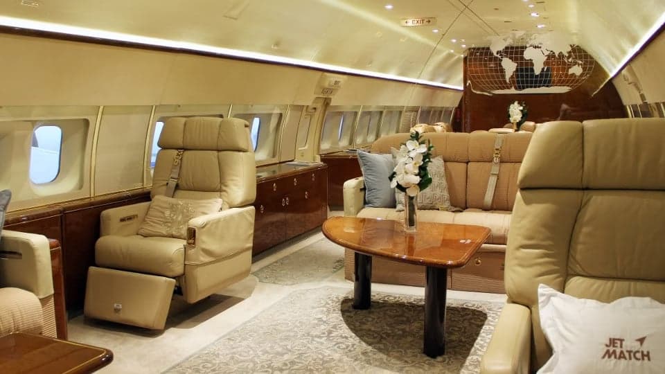 A luxurious aircraft interior with comfortable seating and a world map design.