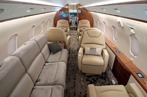 Interior view of the Challenger 300 cabin with leather seats and wood trim.