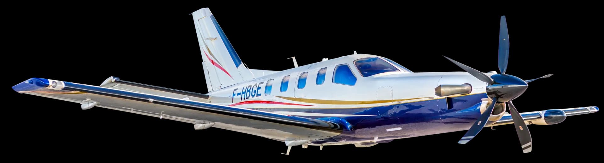 A white and blue Daher TBM turboprop aircraft with registration F-HBGE, viewed from the front-right side.