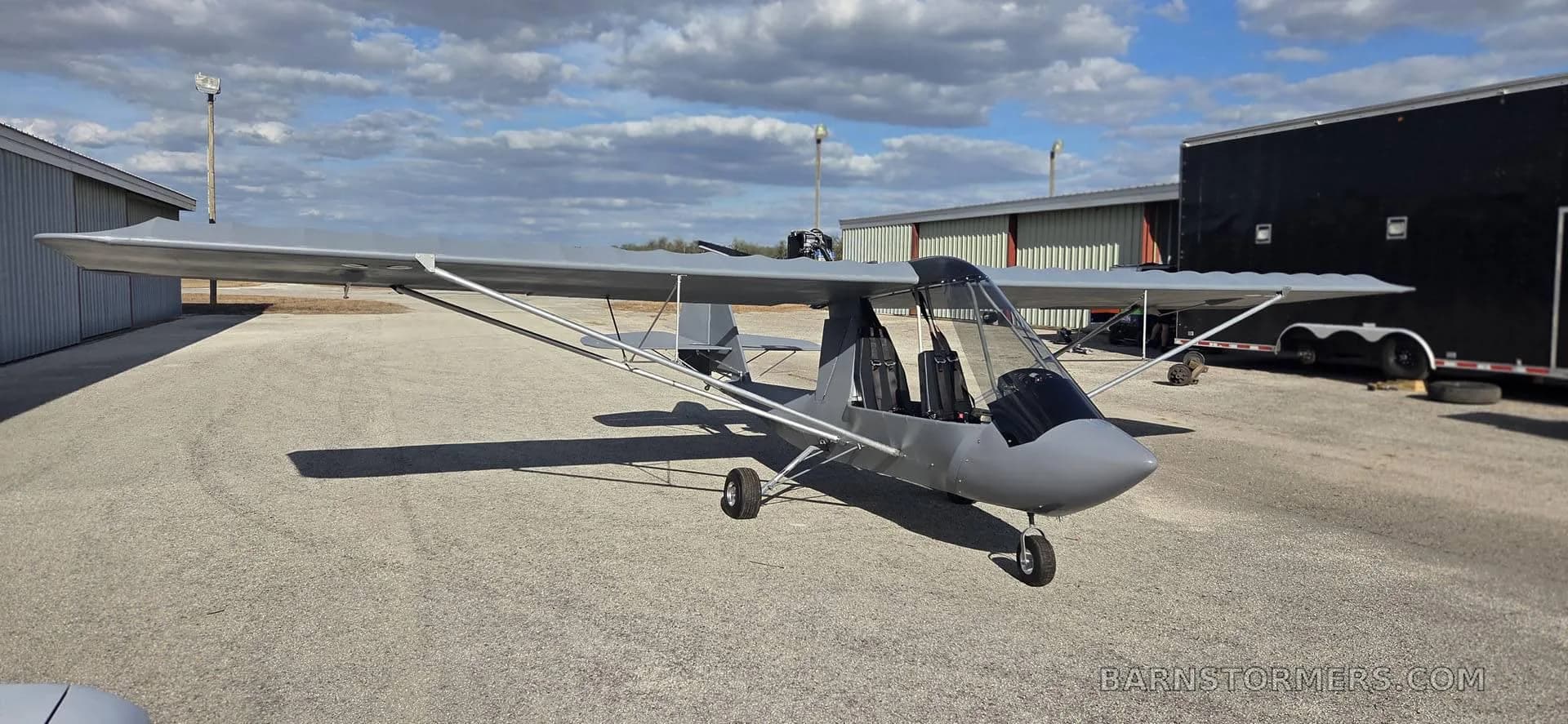 A gray aircraft parked on the tarmac.