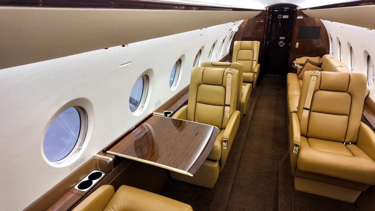 Interior view of the aircraft cabin with tan leather seats.