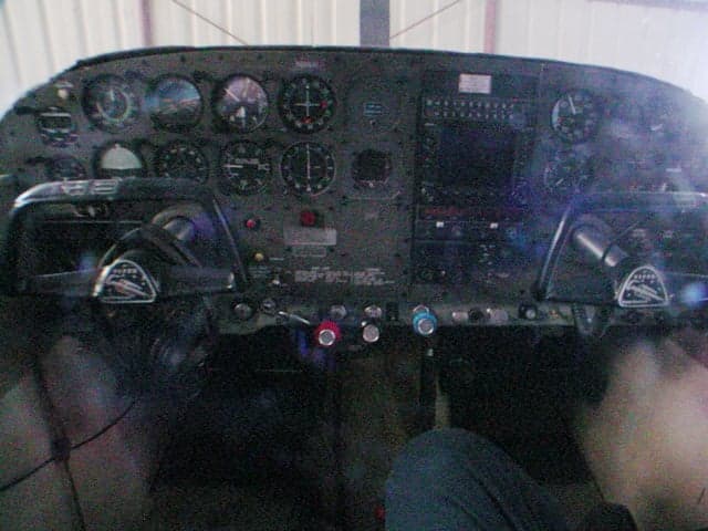 The cockpit instrument panel of a small aircraft, showing various gauges and controls.
