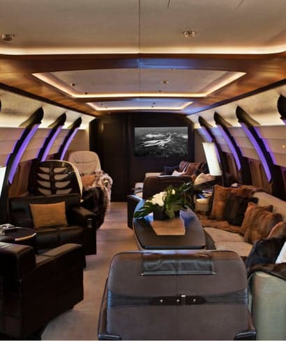 A luxurious aircraft interior with leather seats and wood trim.
