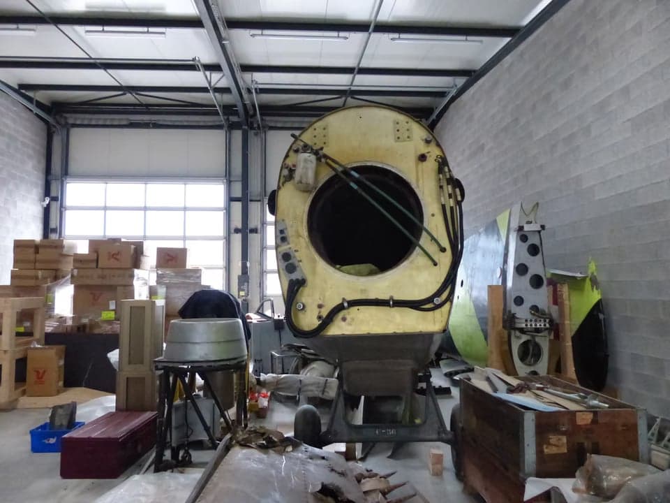 Aircraft engine and fuselage in a hangar.