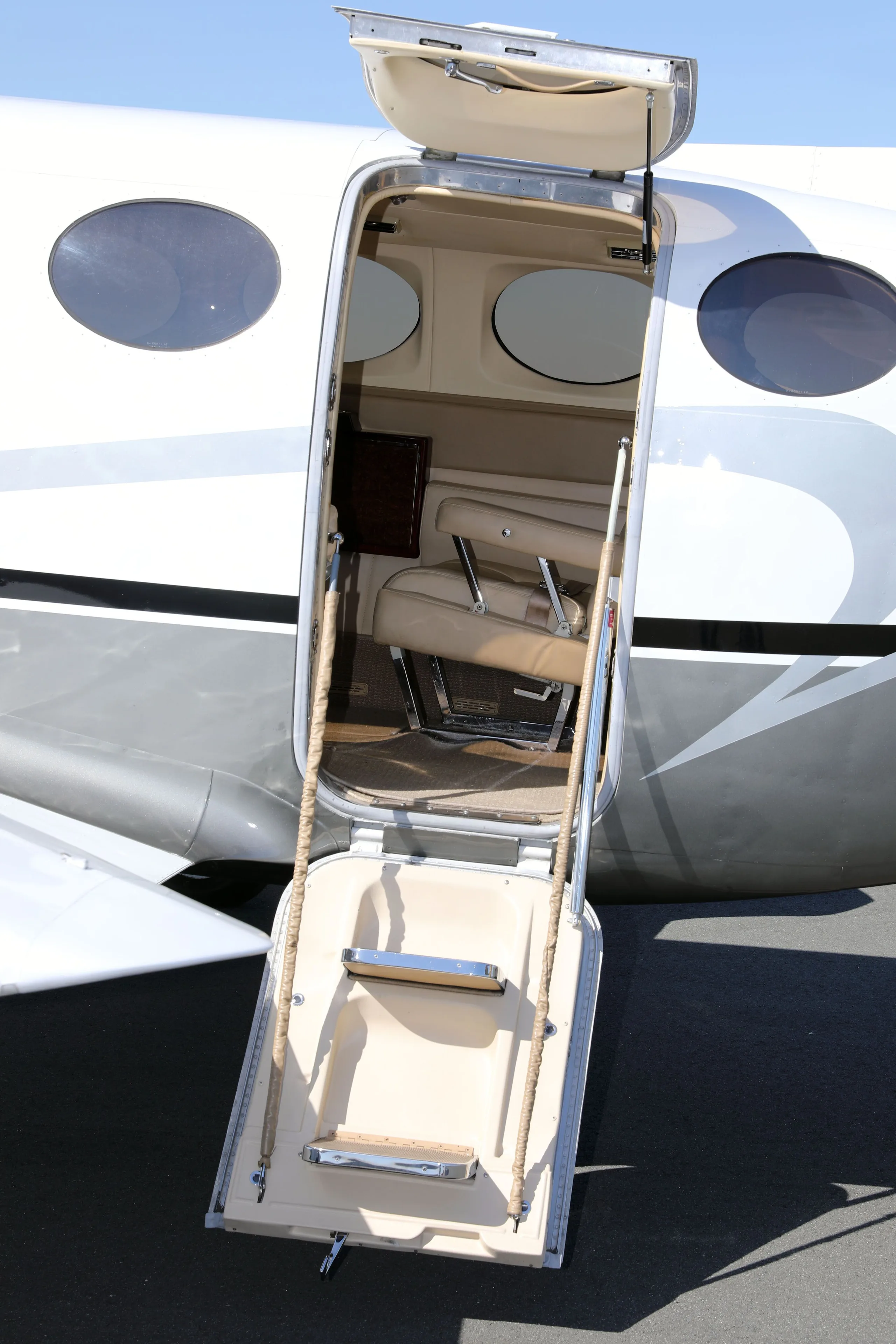 The open passenger door and integrated airstairs of the Cessna 414 Chancellor, N477MG, revealing the beige cabin interior.