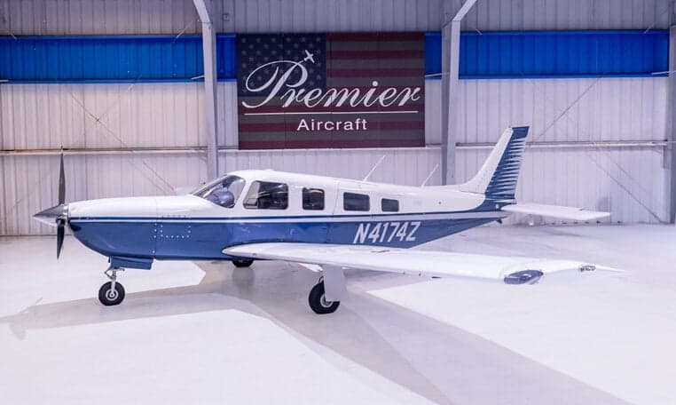Piper PA-28-181 Archer II aircraft with blue and white paint scheme in a hangar, registration N4174Z.