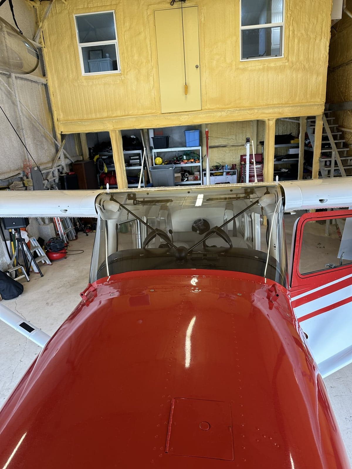 Tail section of a red and white aircraft in a hangar.
