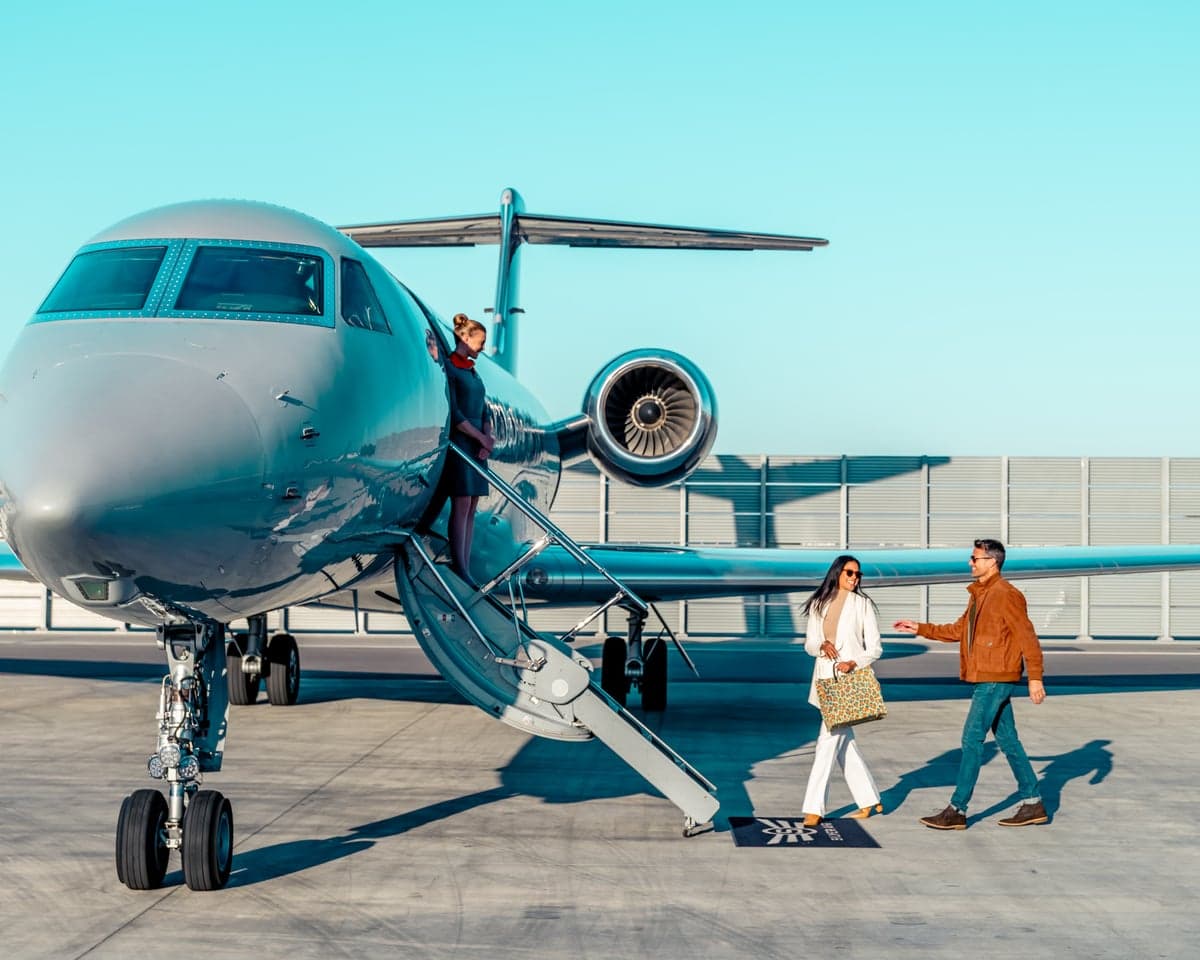 A private jet on the tarmac with passengers boarding.
