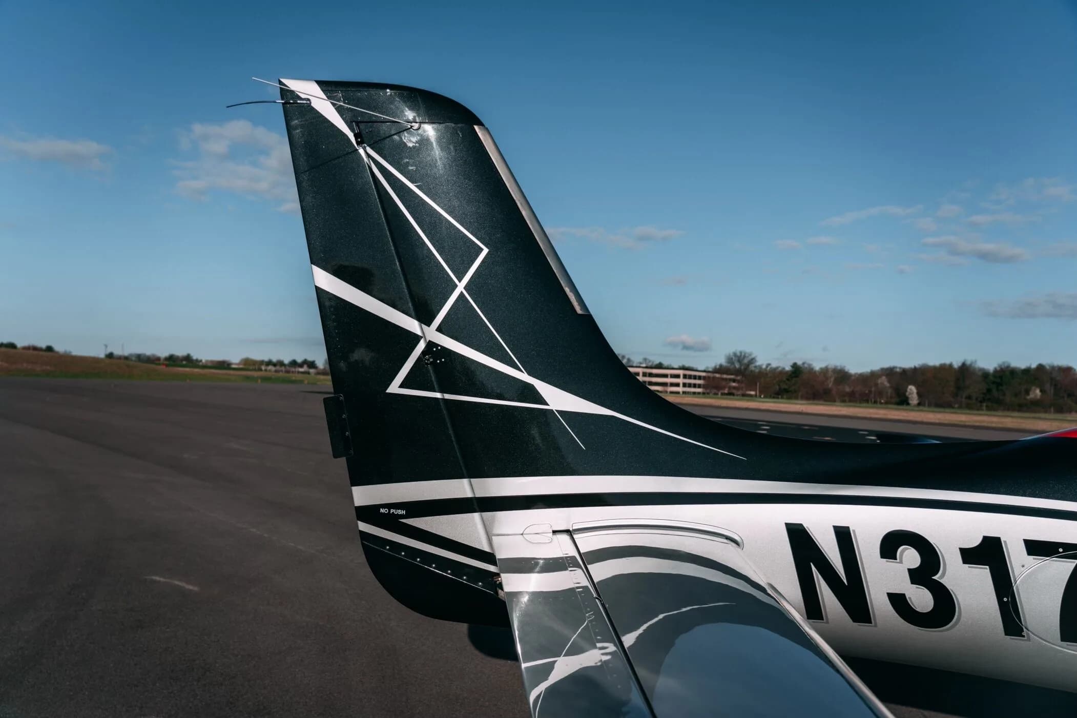 A close-up of the black and silver patterned tail of the Cirrus SR22T aircraft.
