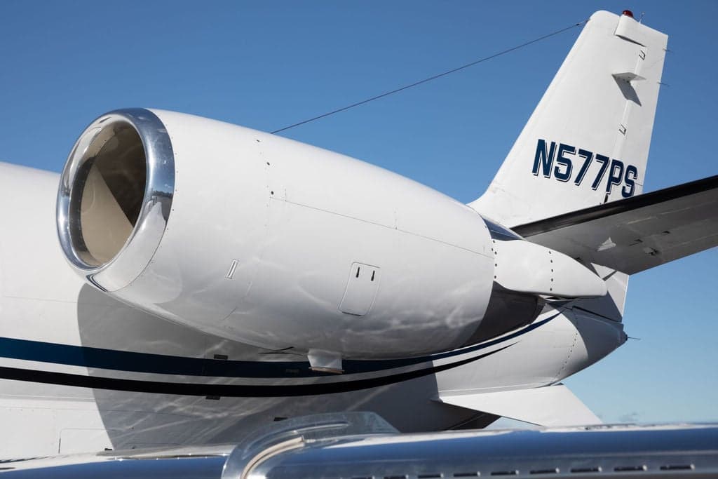 Close-up of the tail and engine of a Cessna Citation CJ3+ aircraft with registration N577PS.